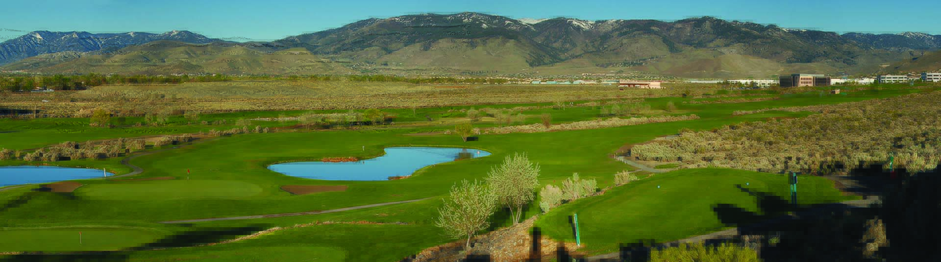 view of golf course green with mountains