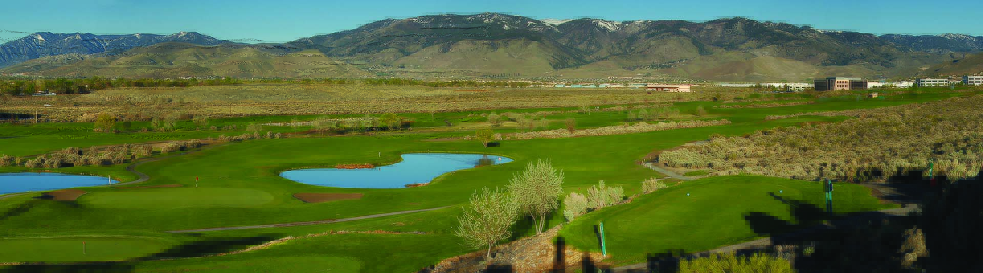 view of golf course green with mountains